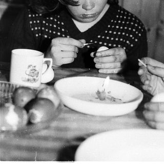 Person eating soup with spoon indoors.