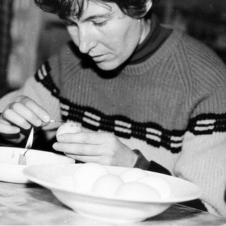 Person meticulously painting or decorating a ceramic bowl.