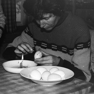 Person decorating Easter eggs with a candle.