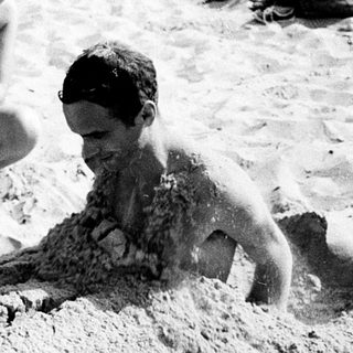 Children playing in sandy beach water.