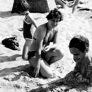 Children playing in sandy beach water.
