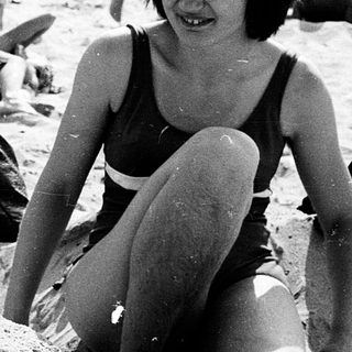 People relaxing on sandy beach in summer.