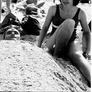 People relaxing on sandy beach in summer.