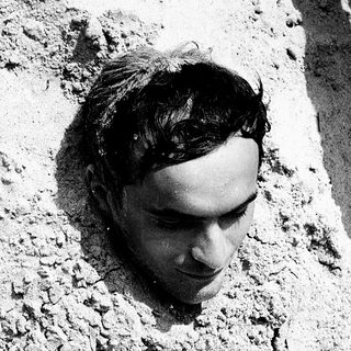 Person lying on cracked, dry ground.
