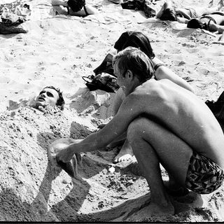 People relaxing and playing in sandy beach sand.
