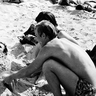 People relaxing and playing in sandy beach sand.