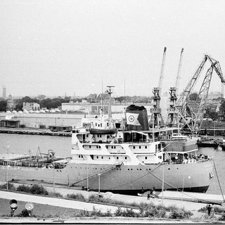 Industrial port with docked cargo ship and cranes.