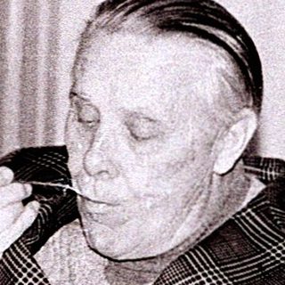Man eating food alone indoors in vintage setting.