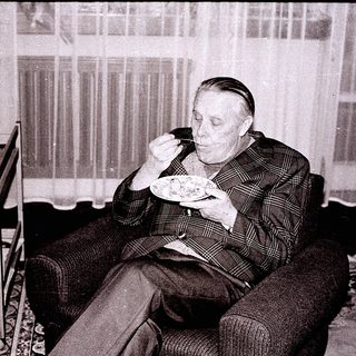 Man eating food alone indoors in vintage setting.