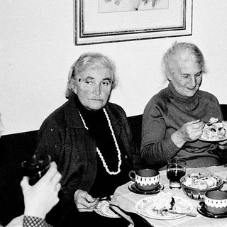 Three elderly people enjoying a meal together indoors.