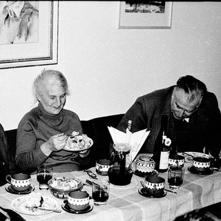 Three elderly people enjoying a meal together indoors.