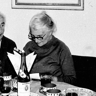 Three elderly women enjoying a meal together indoors.