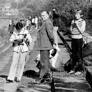 People clearing debris along a rural roadside.