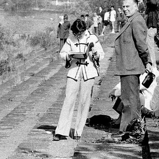 People clearing debris along a rural roadside.