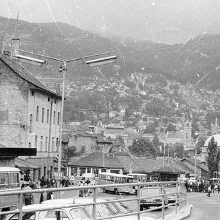 Historic mountain town street scene with buildings and people.