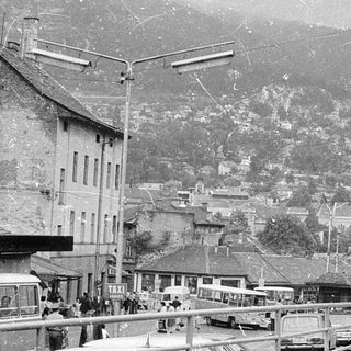 Historic mountain town street scene with buildings and people.