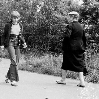 Three people walking outdoors in a park.