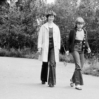 Three people walking outdoors in a park.