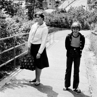 Two people posing on a city hillside path.