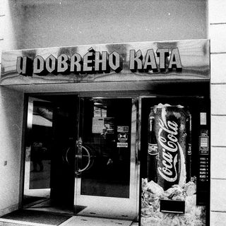 Entrance to "U Dobrého Kata" café with Coca-Cola vending machine.