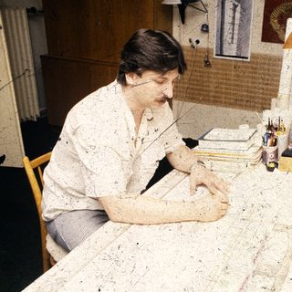 Person working on detailed craft or drawing project.