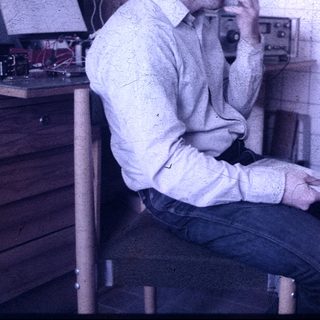Two men discussing in a retro office workspace.