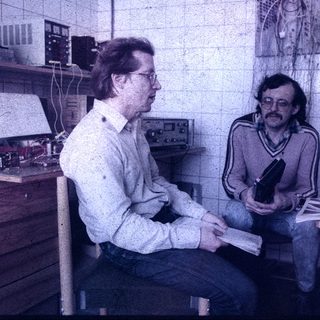 Two men in a workshop examining a camera.
