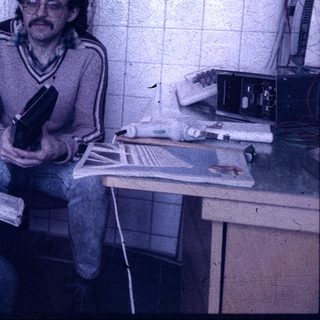 Two men in a workshop examining a camera.