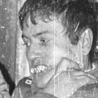 Two men hugging emotionally in an indoor setting.