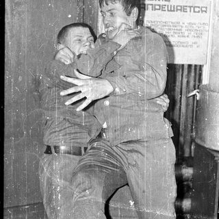 Two men hugging emotionally in an indoor setting.