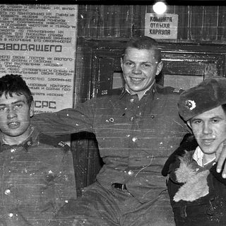 Three young Soviet soldiers posing indoors, 1970s–1980s era.