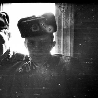 Two soldiers in vintage military uniforms, taken through a window.