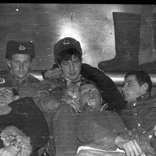 Soldiers in military uniforms during wartime era.