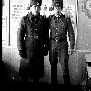 Two young men in Soviet military uniforms, posing for a photo.