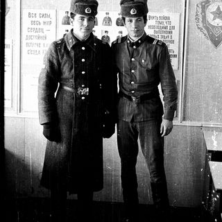 Two young Soviet soldiers in uniform pose together.