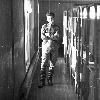 Man standing in narrow, rainy corridor.