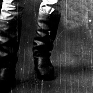 Young man in military uniform standing in train compartment.