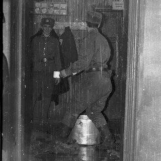 Soldiers clearing flooded subway entrance with helmeted equipment.