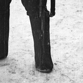 Two soldiers in winter gear standing in snow.