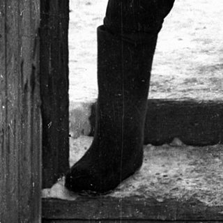 Soldier in winter gear holding submachine gun.