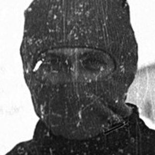 Soldier in winter gear holding submachine gun.
