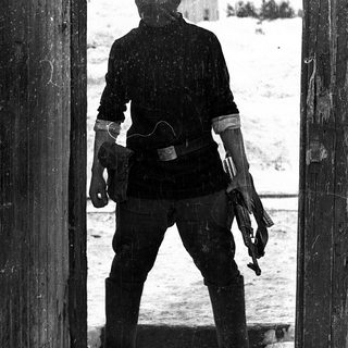 Soldier in winter gear holding submachine gun.