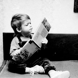 A young child engrossed in reading a book.