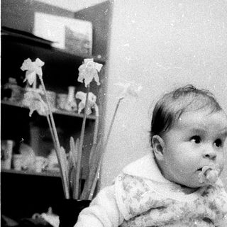 Baby sitting on table with toy.