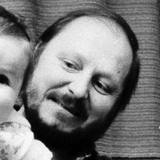 Family portrait with man holding baby, young boy smiling.