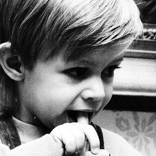 Young child brushing teeth indoors.