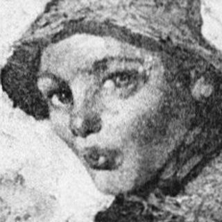 Child posing beside vintage portrait of woman in outdoor attire.