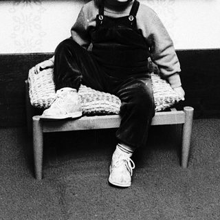 Young child sitting in front of vintage painting.