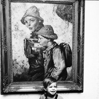 Young child sitting in front of vintage painting.