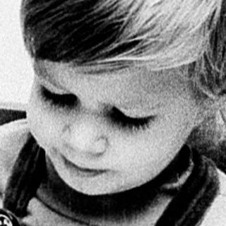 Young child reading book indoors.